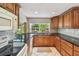 Eat-in kitchen with wood cabinetry and view to backyard at 1265 Royal Oak Dr, Dunedin, FL 34698