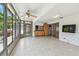 Bright sunroom with tile flooring, neutral walls, and access to the kitchen at 1265 Royal Oak Dr, Dunedin, FL 34698