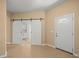 Bright foyer with tile flooring, barn doors to the kitchen, and a white front door at 13049 Moonstone Way, Spring Hill, FL 34609