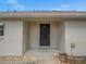 Inviting front entry with a dark wood door, stone pathway, and neutral-colored exterior at 13049 Moonstone Way, Spring Hill, FL 34609