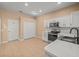 Bright kitchen features white cabinets, modern appliances, and tile flooring at 13049 Moonstone Way, Spring Hill, FL 34609