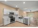 Well-lit kitchen showcasing stainless steel appliances and an open view to the living room at 13049 Moonstone Way, Spring Hill, FL 34609