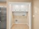 Functional laundry area with cabinetry and tile backsplash at 13049 Moonstone Way, Spring Hill, FL 34609
