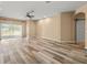 Bright and open living room featuring wood-look flooring, a ceiling fan, and access to the outdoors at 13049 Moonstone Way, Spring Hill, FL 34609