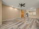 Spacious living room with wood-look floors, ceiling fan, and open floor plan at 13049 Moonstone Way, Spring Hill, FL 34609