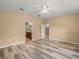 Spacious primary bedroom features wood-look floors, ceiling fan, and ensuite bathroom at 13049 Moonstone Way, Spring Hill, FL 34609