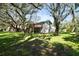Spacious backyard featuring mature trees offering plenty of shade, a deck, and a well-maintained lawn at 13901 Vacation Ln, Odessa, FL 33556