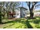 Green backyard with a home, featuring an elevated deck, ground-level parking, and mature trees at 13901 Vacation Ln, Odessa, FL 33556