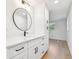 A bright bathroom with white cabinets, black hardware, and quartz countertops at 13901 Vacation Ln, Odessa, FL 33556