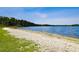 Sandy beach area with clear water, perfect for relaxing by the lake on a sunny day at 13901 Vacation Ln, Odessa, FL 33556