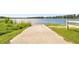 Scenic boat ramp leading to a tranquil lake, surrounded by lush greenery and a clear blue sky at 13901 Vacation Ln, Odessa, FL 33556