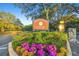 Community entrance to Holiday Club featuring a sign with beautiful landscaping and mature trees at 13901 Vacation Ln, Odessa, FL 33556