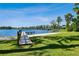 Community lake access with a wooden dock extending into the water, surrounded by lush greenery at 13901 Vacation Ln, Odessa, FL 33556