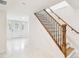Bright foyer with white marble floors and wooden staircase, as seen from the doorway of the main entrance at 13901 Vacation Ln, Odessa, FL 33556