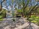 Charming two-story home featuring a light beige exterior, complemented by landscaped yard, wooden deck and lush trees at 13901 Vacation Ln, Odessa, FL 33556