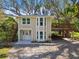 Charming two-story home featuring a light beige exterior, complemented by landscaped yard, wooden deck and lush trees at 13901 Vacation Ln, Odessa, FL 33556