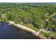 Picturesque aerial view of a lakefront park, featuring a sandy beach, picnic areas, and lush greenery at 13901 Vacation Ln, Odessa, FL 33556