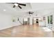 Open-concept living area with light wood floors, recessed lighting, and seamless access to the modern kitchen at 13901 Vacation Ln, Odessa, FL 33556