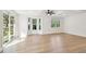 Bright living room boasts beautiful light wood floors and multiple windows for natural light at 13901 Vacation Ln, Odessa, FL 33556