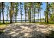 Lakeside volleyball court with a sandy surface and a picturesque view of the calm lake at 13901 Vacation Ln, Odessa, FL 33556