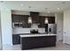 Modern kitchen with stainless steel appliances, dark cabinetry, and a center island with a sink at 14425 Maiden Ter, Lakewood Ranch, FL 34211