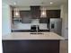 Modern kitchen with stainless steel appliances, dark cabinetry, and a center island with a sink at 14425 Maiden Ter, Lakewood Ranch, FL 34211