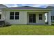 Rear exterior showcasing sliding glass doors to the backyard with a grassy lawn at 14429 Maiden Ter, Lakewood Ranch, FL 34211