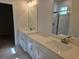 Modern bathroom with dual vanities, elegant mirrors, and contemporary lighting fixtures at 14437 Maiden Ter, Lakewood Ranch, FL 34211