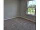 Light-filled bedroom with carpeting and a window offering views of the outside landscape at 14437 Maiden Ter, Lakewood Ranch, FL 34211