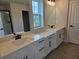 Bathroom showcasing dual vanities, quartz countertop, framed mirror, and sleek black hardware at 14441 Maiden Ter, Lakewood Ranch, FL 34211