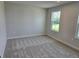 Bedroom with neutral carpet and base molding, offering a view of nature through a window at 14441 Maiden Ter, Lakewood Ranch, FL 34211