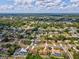 Expansive aerial view of a residential area with lush trees, highlighting the neighborhood's layout and environment at 14646 Coronado Dr, Spring Hill, FL 34609