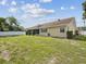 Wide-angle shot of spacious backyard, offering a well-kept lawn, screened patio, and full fencing at 14646 Coronado Dr, Spring Hill, FL 34609