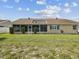 Spacious backyard featuring a well-maintained lawn, screened patio, and partial fencing at 14646 Coronado Dr, Spring Hill, FL 34609