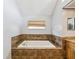 Bathroom showcasing a tiled bathtub and window with natural light at 14646 Coronado Dr, Spring Hill, FL 34609