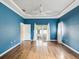 Large bedroom with blue walls, a ceiling fan, hardwood floors, and a sliding glass door at 14646 Coronado Dr, Spring Hill, FL 34609