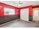 Bright bedroom featuring red walls, gray carpet, ceiling fan, and a spacious closet at 14646 Coronado Dr, Spring Hill, FL 34609