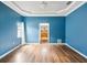 Bedroom with blue walls, hardwood floors, a ceiling fan, and a view of the hallway at 14646 Coronado Dr, Spring Hill, FL 34609