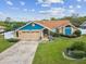 Inviting single-Gathering home featuring a well-maintained lawn, lush landscaping, and an attached two-car garage at 14646 Coronado Dr, Spring Hill, FL 34609