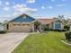 Inviting single-Gathering home with a manicured lawn, lush landscaping, and a two-car garage at 14646 Coronado Dr, Spring Hill, FL 34609