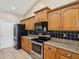 Modern kitchen featuring stainless steel appliances, black tile backsplash and wood cabinets at 14646 Coronado Dr, Spring Hill, FL 34609