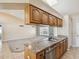 Bright kitchen featuring wood cabinets, stainless steel sink, and views into the living area at 14646 Coronado Dr, Spring Hill, FL 34609