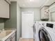 Laundry room featuring modern washer and dryer, utility sink, and storage cabinets at 14646 Coronado Dr, Spring Hill, FL 34609