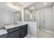 Modern bathroom featuring a gray vanity with quartz countertop, a framed mirror, and glass-enclosed shower at 1783 Oak Hammock Ct, Lutz, FL 33558