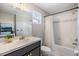 Well-lit bathroom featuring a tub with shower, tile accents, and a modern vanity with marble countertop at 1783 Oak Hammock Ct, Lutz, FL 33558