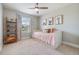 A cozy bedroom boasts carpeted floors, a ceiling fan, and themed artwork, creating an inviting space at 1783 Oak Hammock Ct, Lutz, FL 33558