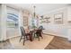 Cozy dining area featuring a wooden table set for four, a modern chandelier, and a serene view at 1783 Oak Hammock Ct, Lutz, FL 33558