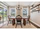 An elegant dining room features a wooden table, black chairs, a modern chandelier, and a view to the water at 1783 Oak Hammock Ct, Lutz, FL 33558