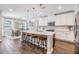 Modern kitchen featuring a large center island with seating, white cabinets, and stainless steel appliances at 1783 Oak Hammock Ct, Lutz, FL 33558