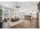 Open-concept living room boasts wood-look tile flooring, a large sectional sofa, and a seamless flow into the kitchen at 1783 Oak Hammock Ct, Lutz, FL 33558